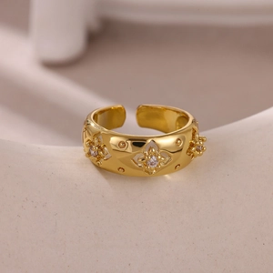 Macro shot of gold-plated open ring with镂空flower patterns and small zircon stones