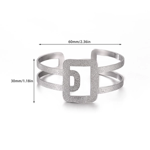 Detalle de brazalete geométrico de acero inoxidable con 60mm de diámetro y 30mm de ancho