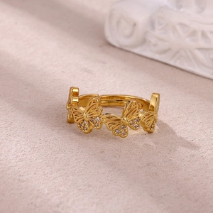 Detail of gold butterfly ring featuring zircon-encrusted wings and open-band design