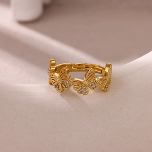 Macro detail of gold-plated butterfly ring with intricate filigree and zircon accents