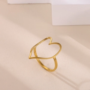 Macro view of gold-plated hollow heart ring showing intricate cutout lines and texture