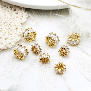 Macro detail of 18K gold plated cylinder pendants with zircon for DIY jewelry making