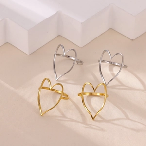 Minimalist open heart rings in gold and silver finish on a modern white geometric stand