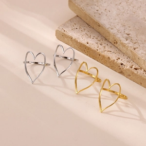 Detail view of hollow heart rings in gold and silver finish on travertine stone