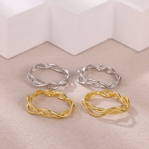 Minimalist interwoven openwork rings in gold and silver finish shown from a 45-degree angle
