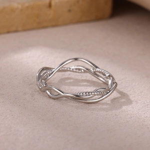 Macro detail of silver twisted wave ring with irregular hollow lines in minimalist style