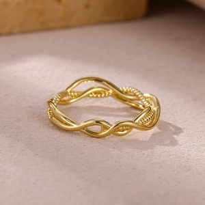 Detail of gold double-layer twisted ring showing smooth and beaded texture contrast