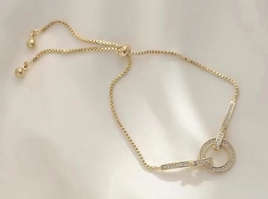 Close-up of 18K gold plated box chain bracelet with adjustable slider and pavé ring