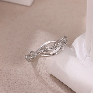 Detailed view of silver stainless steel ring with intertwined smooth and beaded textured lines