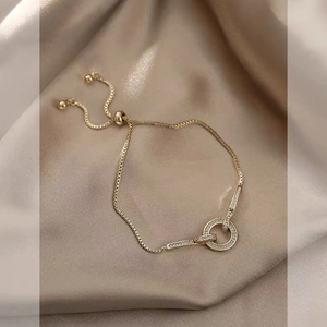 Detail of adjustable 18K gold plated box chain bracelet with sparkling zircon charms