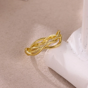Macro shot of gold-plated stainless steel ring with beaded and smooth twisted textures