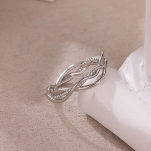 Detailed close-up of a silver twisted ring featuring smooth and beaded intertwined bands