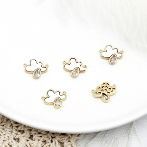 Detalle de dijes de nube con gotas de circón y diseño de corazón calado al dorso