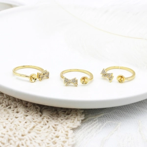 Detail of 18K gold-plated bow rings with zircon settings and pearl base for DIY jewelry