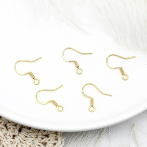 Macro detail of five 18K gold plated earring hooks with S925 hallmark on white ceramic