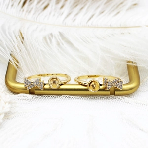 Macro detail of 18K gold-plated bow ring setting with micro-pave cubic zirconia accents