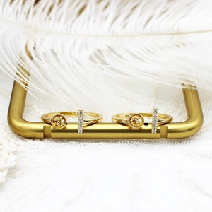 Detailed view of 18K gold plated bow ring with zircon vertical bar on feather background