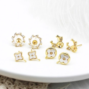 Vue détaillée des apprêts de boucles d'oreilles trèfle et cerf plaqués or 18 carats