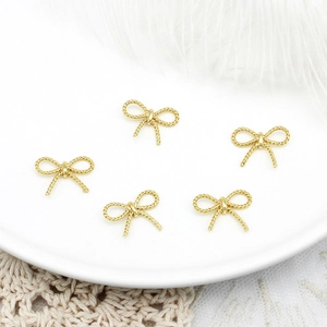 Macro-opname van 5 vergulde strikhangers met touwtextuur voor DIY-sieraden maken