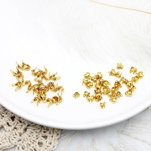 Detailed view of 18K gold plated bead tips for DIY jewelry making on white lace