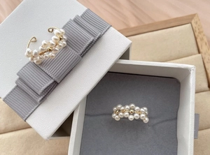 Détail de bagues en perles faites main plaquées or 18 carats dans un écrin cadeau