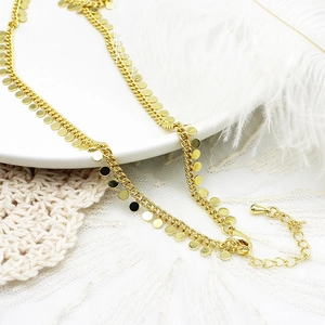 Detail van 18K vergulde box-ketting met ronde pailletten hangers en een kreeftsluiting