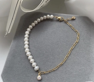 Dettaglio catena placcata oro 18K con perle bianche e ciondolo a cerchio pavé lucido