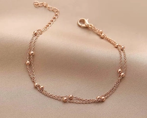 Dettaglio della catena a doppio strato con sfere placcata oro 18K e chiusura regolabile
