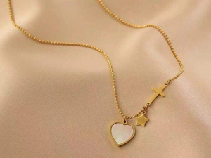 Dettaglio catena a sfere placcata oro 18K con ciondoli a cuore, stella e croce