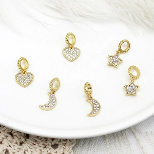 Macro shot of 18K gold plated heart, star and moon charms with zircon micro-paving