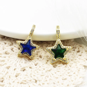 Dettaglio di pendenti a stella placcati oro con zirconi micro-pavé blu e verdi