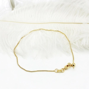 Detail of adjustable 18K gold plated box chain bracelet with lobster clasp and slider bead