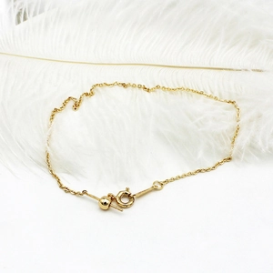 Detail of adjustable 18K gold plated cable chain featuring a spring clasp and bead