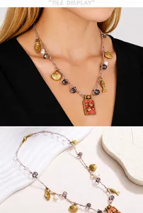 Detail van geweven touwketting met kleine vissen, parelhangers en rode emaille hanger