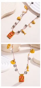Detailopname van de handgemaakte roze geweven ketting met gouden visbedels en parels