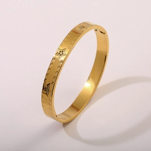 Dettaglio del bracciale in acciaio placcato oro 18K con stelle incise e zirconi
