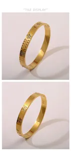 Dettaglio di bracciali dorati con motivi a farfalla in rilievo e cuori floreali