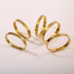 Cinque bracciali in acciaio inossidabile placcato oro 18K con ciondoli in zircone su beige