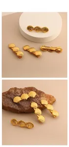Detailaufnahme der goldenen Muschel-Haarspange mit fächerförmiger Textur und Entenschnabelclip