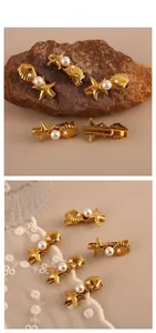 Detailansicht goldener Haarspangen mit Seestern, Muschel und weißen Perlen auf Spitze