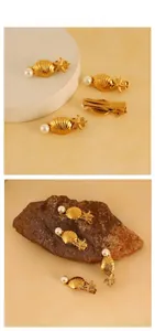 Detailansicht der goldenen Muschel Haarspange mit Seestern und Perle auf Dekor