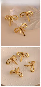 Detail showing elegant gold bow hairpins with liquid metal texture on white ceramic plates