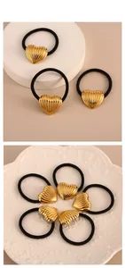 Detail showing elastic hair ties with gold textured heart charms on a display plate