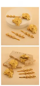 Detail view of gold starfish hairpins and straw hat clips with pearls on a stone stand