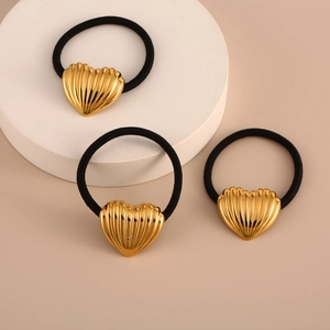 Three-piece set of black elastic hair ties with gold heart-shaped ribbed metal charms