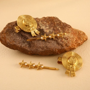 Haarklammer-Set in Gold mit Muschel- und Sterndesign sowie Perlen auf Naturstein