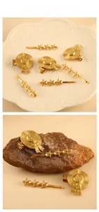 Detailed view of gold straw hat and starfish hair clips with white pearls on a stone