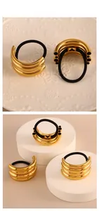 Détail de l'attache-cheveux en métal doré 18K en forme de C avec élastique noir robuste