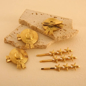 Golden straw hat and starfish hair clips with pearls on a textured stone background
