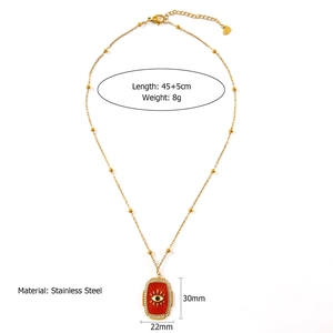 Detail view of gold-tone stainless steel necklace with red enamel evil eye pendant